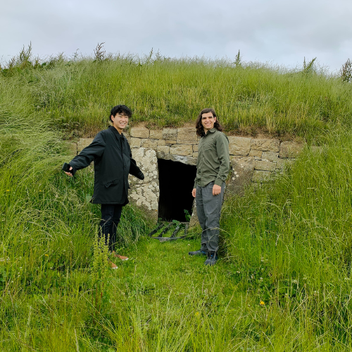 Two students outside a portal tomb in Ireland.